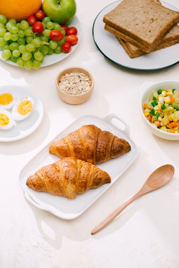 Het gezonde Ontbijt diende met melk, croissants, ei, graangewassen, havermeel en vruchten stock foto's Het gezonde Ontbijt diende met melk, croissants, ei, graangewassen, havermeel en vruchten stock foto's