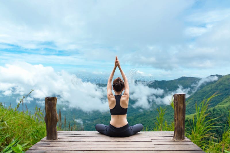 Het gezonde vrouw levensstijl evenwichtige praktizeren mediteren en zen de energieyoga op de brug in ochtend de bergaard