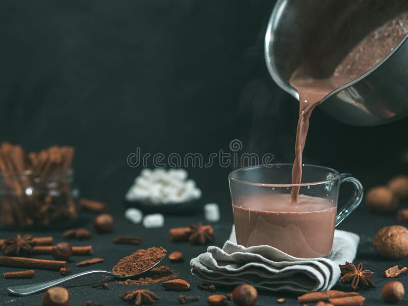 Het gieten van smakelijke cacaodrank in mok op lijst