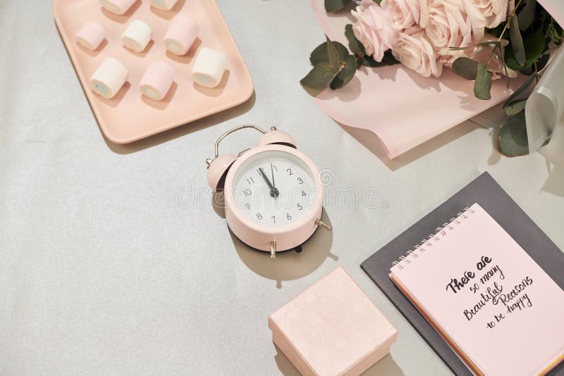 Het giftvakje, wekker en roze nam bloemen op witte lijst toe stock foto Het giftvakje, wekker en roze nam bloemen op witte lijst toe stock foto