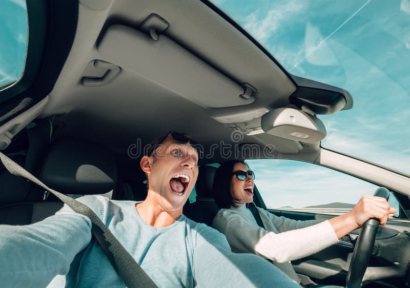 Het gillen paar het berijden in mening van de auto de brede hoek stock fotografie Het gillen paar het berijden in mening van de auto de brede hoek stock fotografie