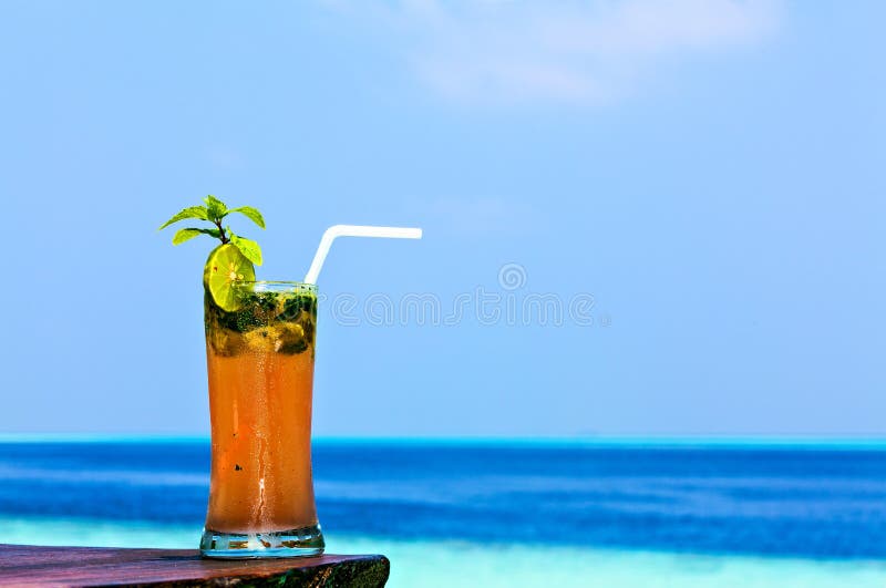 Het glas van drank is op een strandlijst royalty-vrije stock fotografie Het glas van drank is op een strandlijst royalty-vrije stock fotografie