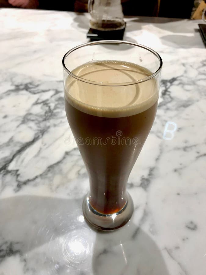 Het glas van Nitrokoude brouwt Koffie op Marmeren Oppervlakte Klaar te dienen royalty-vrije stock afbeeldingen Het glas van Nitrokoude brouwt Koffie op Marmeren Oppervlakte Klaar te dienen royalty-vrije stock afbeeldingen
