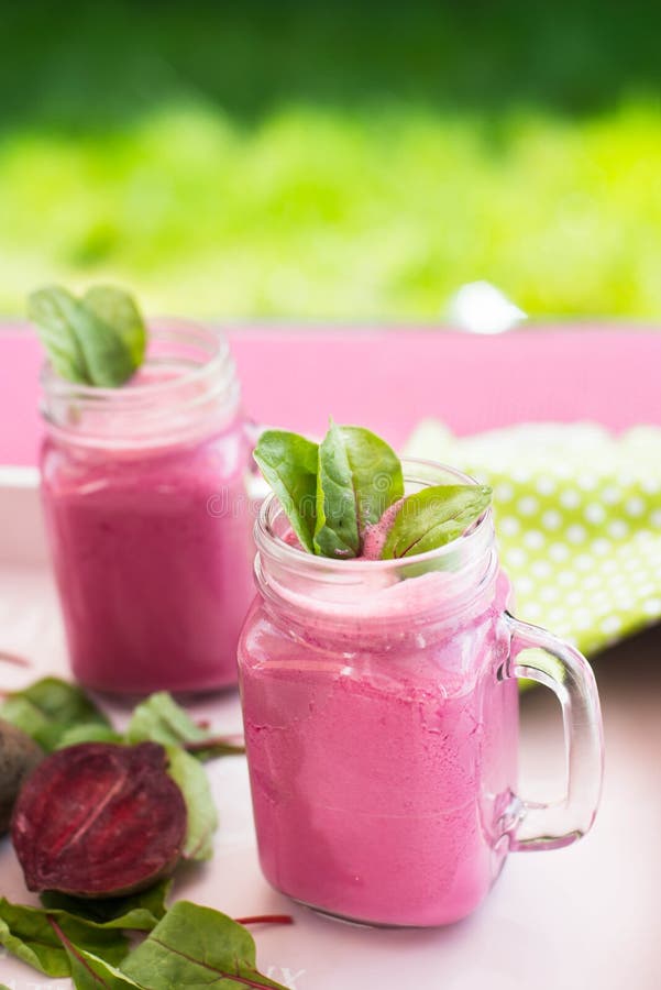 Het glas vers bietensap met weddenschappen en doorbladert Bieten smoothie in kruik Roze Detox stock foto's Het glas vers bietensap met weddenschappen en doorbladert Bieten smoothie in kruik Roze Detox stock foto's
