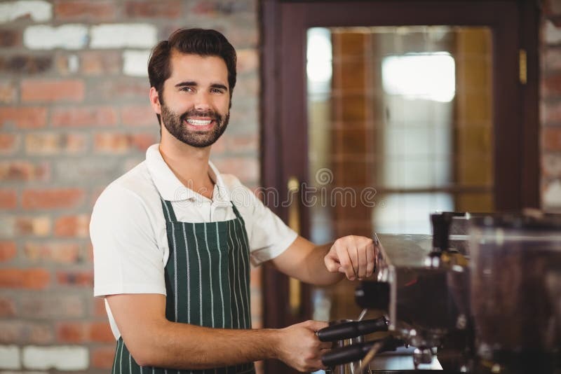 Het glimlachen barista die een koffie voorbereiden royalty-vrije stock afbeeldingen Het glimlachen barista die een koffie voorbereiden royalty-vrije stock afbeeldingen