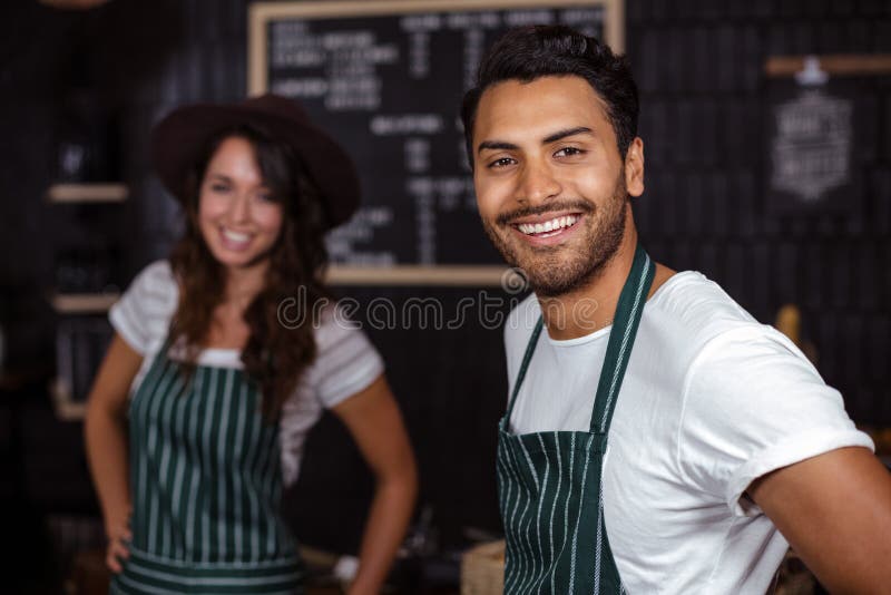 Het glimlachen baristas die de camera bekijken royalty-vrije stock foto Het glimlachen baristas die de camera bekijken royalty-vrije stock foto