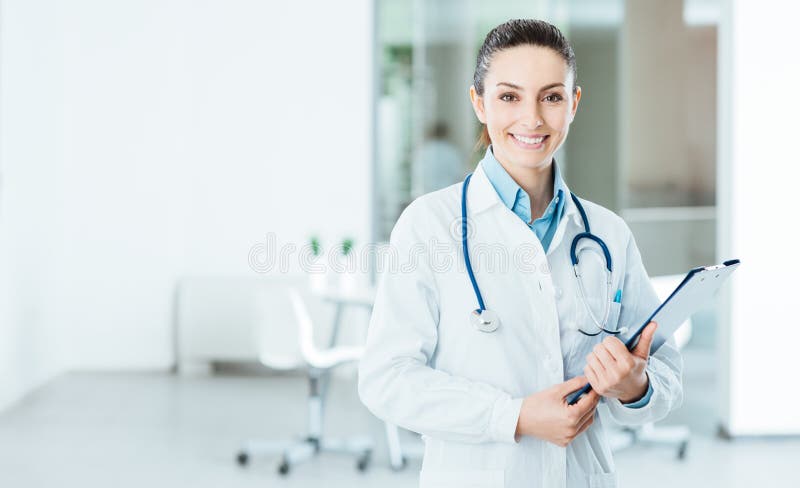 Smiling female doctor with lab coat in her office holding a clipboard with medical records, she is looking at camera. Smiling female doctor with lab coat in her office holding a clipboard with medical records, she is looking at camera