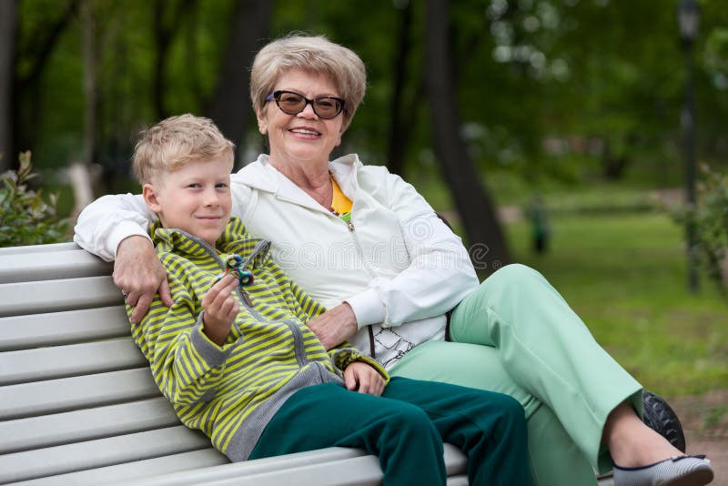 Het glimlachen kleinzoon het spelen met spinnergadget, gelukkige oma die jongen, twee personen koesteren royalty-vrije stock foto Het glimlachen kleinzoon het spelen met spinnergadget, gelukkige oma die jongen, twee personen koesteren royalty-vrije stock foto