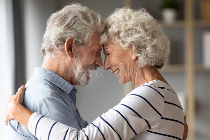 Het glimlachen van volwassen man en vrouw delen een romantisch moment samen