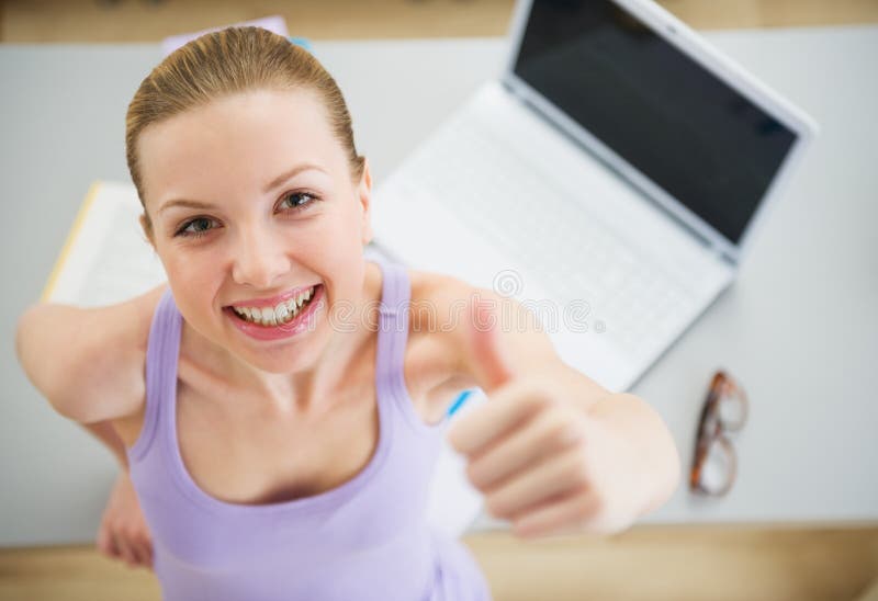 Het glimlachen vrouw het bestuderen in keuken en het tonen beduimelen omhoog stock foto's Het glimlachen vrouw het bestuderen in keuken en het tonen beduimelen omhoog stock foto's