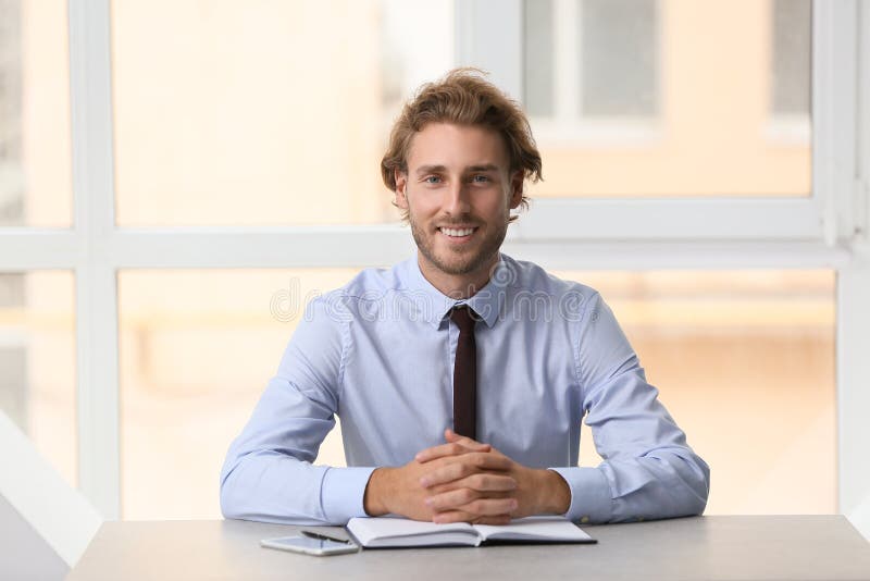Het glimlachen zakenmanzitting bij lijst dichtbij venster stock afbeelding Het glimlachen zakenmanzitting bij lijst dichtbij venster stock afbeelding