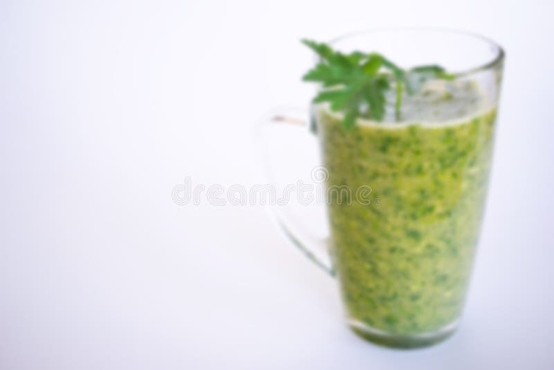 Het groene fruit en plantaardige smoothie met een twijg van peterselie in een transparant glas overvallen op een witte achtergron stock afbeeldingen Het groene fruit en plantaardige smoothie met een twijg van peterselie in een transparant glas overvallen op een witte achtergron stock afbeeldingen