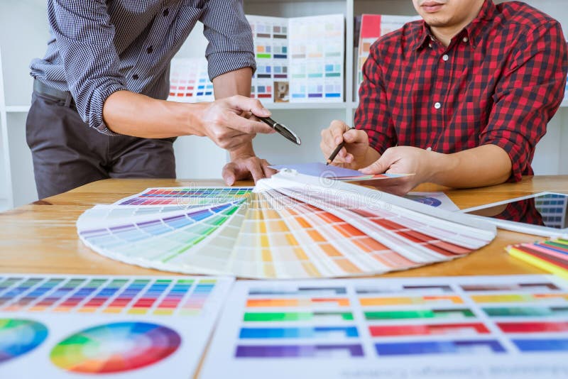 Het groepswerk van jonge creatieve ontwerpers die aan project samenwerken en kiest de steekproeven van het kleurenmonster voor se royalty-vrije stock afbeeldingen Het groepswerk van jonge creatieve ontwerpers die aan project samenwerken en kiest de steekproeven van het kleurenmonster voor se royalty-vrije stock afbeeldingen