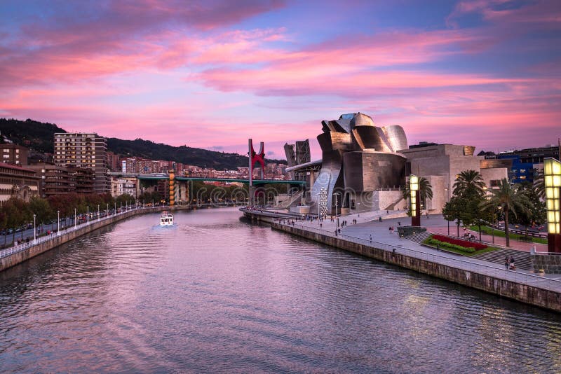 Het Guggenheim-Museum Bilbao, Nervion-Rivier en La-Wondzalfbrug bij roze zonsondergang in Bilbao, Spanje stock fotografie Het Guggenheim-Museum Bilbao, Nervion-Rivier en La-Wondzalfbrug bij roze zonsondergang in Bilbao, Spanje stock fotografie