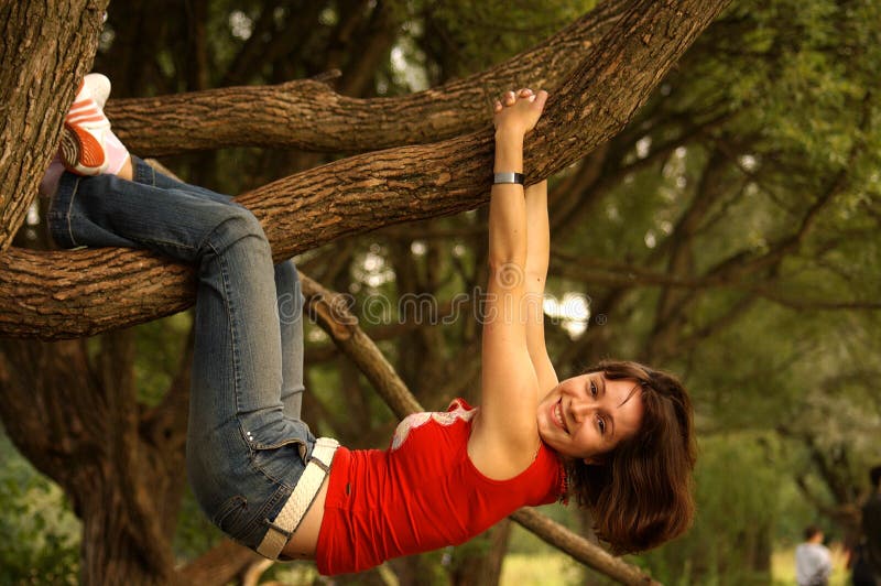 Brown-haired young woman hanging on willow branch. Brown-haired young woman hanging on willow branch