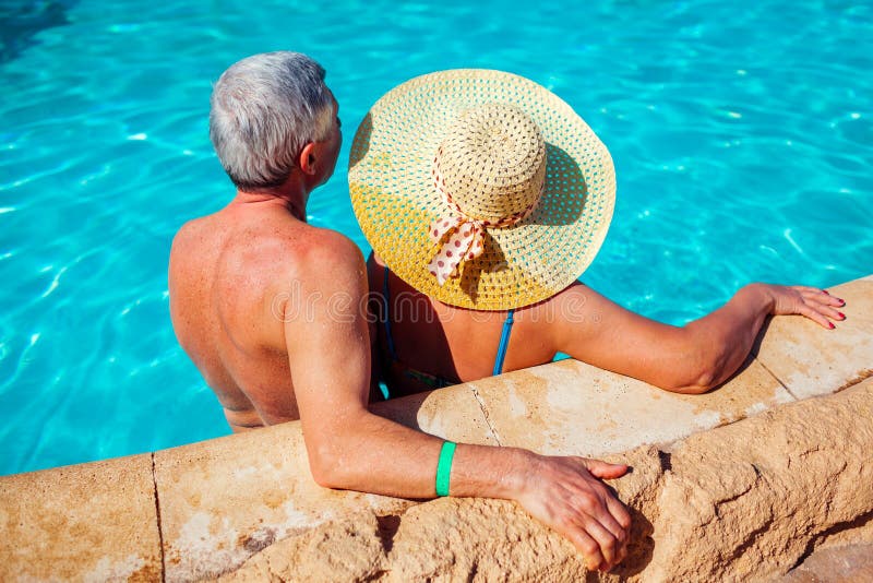 Het hogere paar ontspannen in zwembad Mensen die de zomer van vakantie genieten Inclusief allen royalty-vrije stock afbeelding Het hogere paar ontspannen in zwembad Mensen die de zomer van vakantie genieten Inclusief allen royalty-vrije stock afbeelding