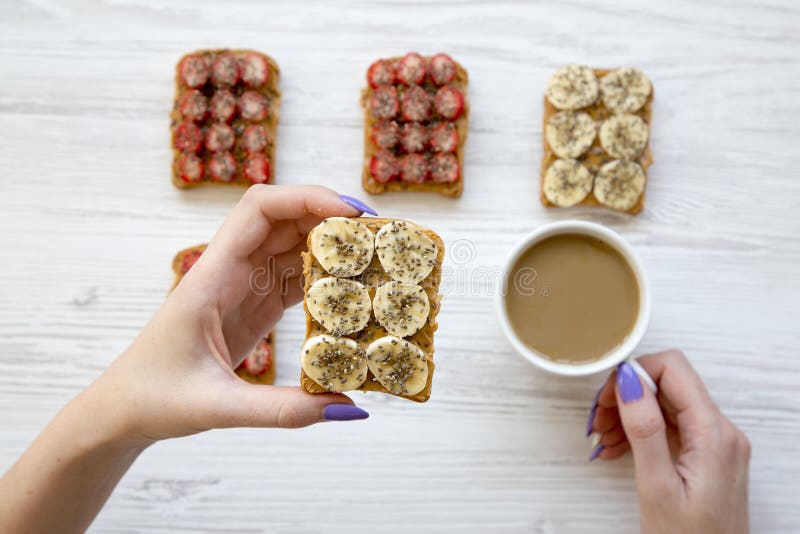 Het hoogste menings jonge meisje houdt veganisttoost en koffie over witte houten achtergrond stock fotografie Het hoogste menings jonge meisje houdt veganisttoost en koffie over witte houten achtergrond stock fotografie