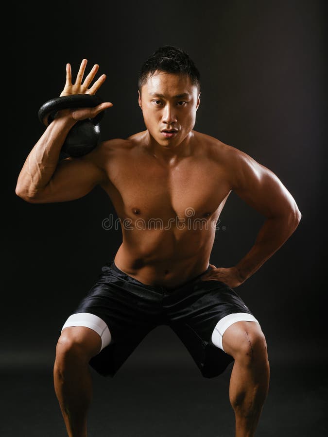 Het houden van een kettlebell en het doen van hurkzit royalty-vrije stock afbeelding Het houden van een kettlebell en het doen van hurkzit royalty-vrije stock afbeelding