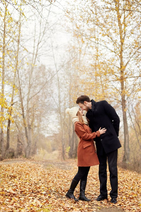 Het houden van paargangen in het de de de herfstpark, omhelzingen en kussen Vrouw i stock fotografie Het houden van paargangen in het de de de herfstpark, omhelzingen en kussen Vrouw i stock fotografie