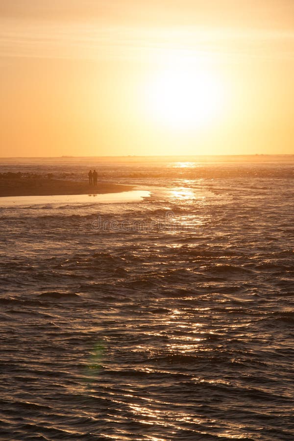 Het houdende van paar loopt op het overzeese strand in de warme stralen van de zonsondergang royalty-vrije stock fotografie Het houdende van paar loopt op het overzeese strand in de warme stralen van de zonsondergang royalty-vrije stock fotografie