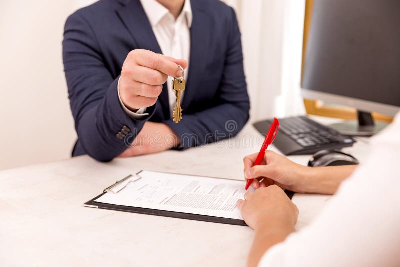 Het huissleutel van de makelaar in onroerend goedholding tot zijn cliënt na naar huis het ondertekenen van contract, concept voor royalty-vrije stock afbeeldingen Het huissleutel van de makelaar in onroerend goedholding tot zijn cliënt na naar huis het ondertekenen van contract, concept voor royalty-vrije stock afbeeldingen