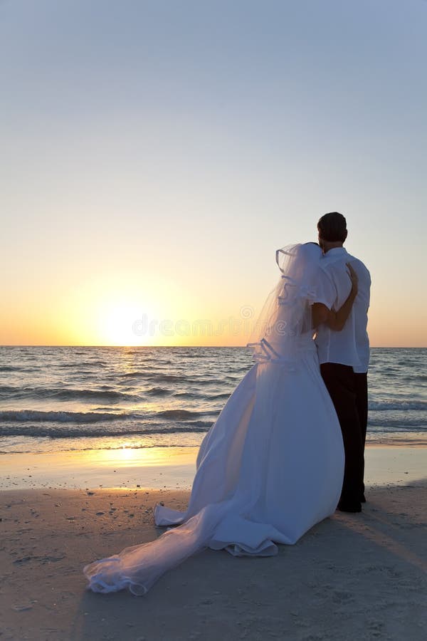 Het Huwelijk van het Strand van de Zonsondergang van het Echtpaar van de bruid & van de Bruidegom royalty-vrije stock afbeeldingen Het Huwelijk van het Strand van de Zonsondergang van het Echtpaar van de bruid & van de Bruidegom royalty-vrije stock afbeeldingen