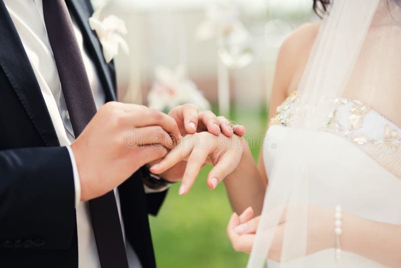 Het huwelijkspaar overhandigt close-up tijdens huwelijksceremonie