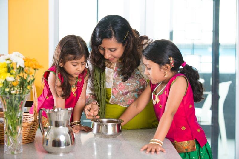 Het Indische moeder koken met haar dochters stock foto Het Indische moeder koken met haar dochters stock foto
