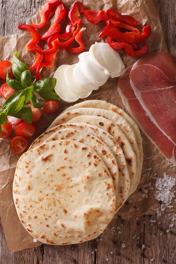 Het Italiaans bakte vers piadina met ingrediëntenclose-up Vertica stock afbeelding Het Italiaans bakte vers piadina met ingrediëntenclose-up Vertica stock afbeelding