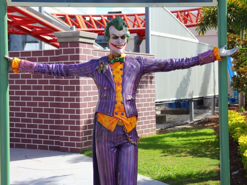 The sculpture of The Joker - Batmans adversary - in a Theme Park setting. Roller coaster tracks in the background. The sculpture of The Joker - Batmans adversary - in a Theme Park setting. Roller coaster tracks in the background.