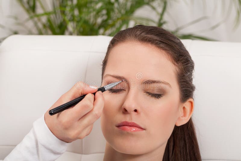 Het jonge aantrekkelijke de schaduw van het de wenkbrauwpoeder van de vrouwenmake-up van toepassing zijn stock foto Het jonge aantrekkelijke de schaduw van het de wenkbrauwpoeder van de vrouwenmake-up van toepassing zijn stock foto