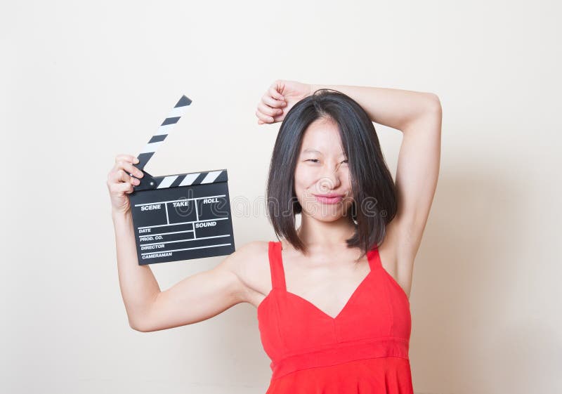 Het jonge Aziatische grappige gezicht van de vrouwen rode kleding met clapperboard stock foto's Het jonge Aziatische grappige gezicht van de vrouwen rode kleding met clapperboard stock foto's