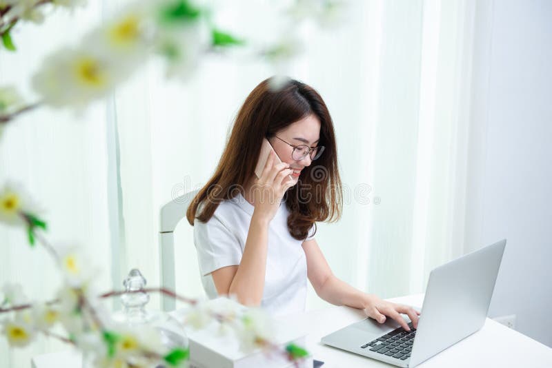 Het jonge Aziatische meisje is freelancer thuis met haar particuliere sector stock afbeelding Het jonge Aziatische meisje is freelancer thuis met haar particuliere sector stock afbeelding