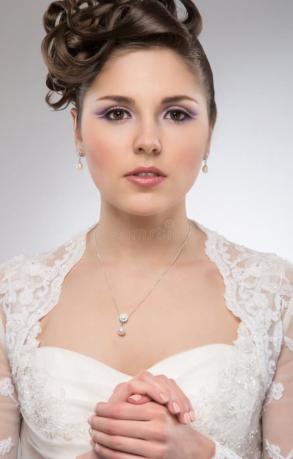 Het jonge donkerbruine bruid stellen in een witte kleding royalty-vrije stock fotografie Het jonge donkerbruine bruid stellen in een witte kleding royalty-vrije stock fotografie