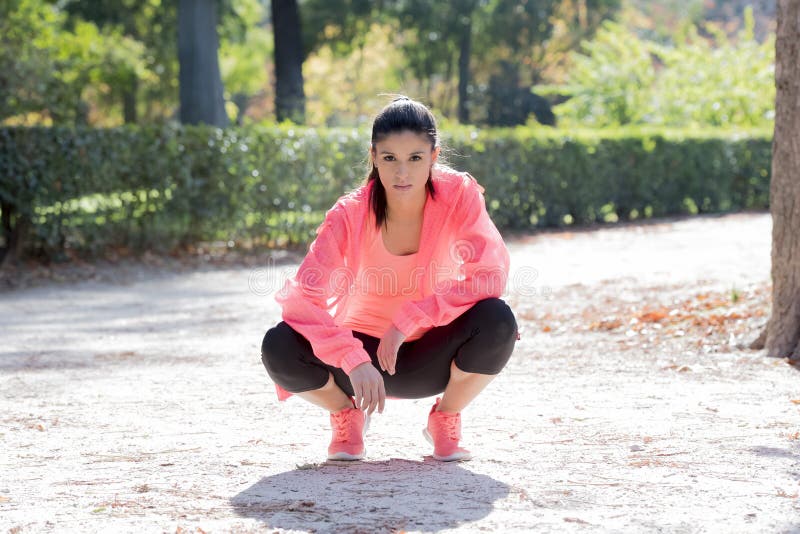 Het jonge gelukkige en aantrekkelijke de vrouw van de sportagent stellen ontspande bij stadspark kijkend geschikt en gezond na op stock foto's Het jonge gelukkige en aantrekkelijke de vrouw van de sportagent stellen ontspande bij stadspark kijkend geschikt en gezond na op stock foto's