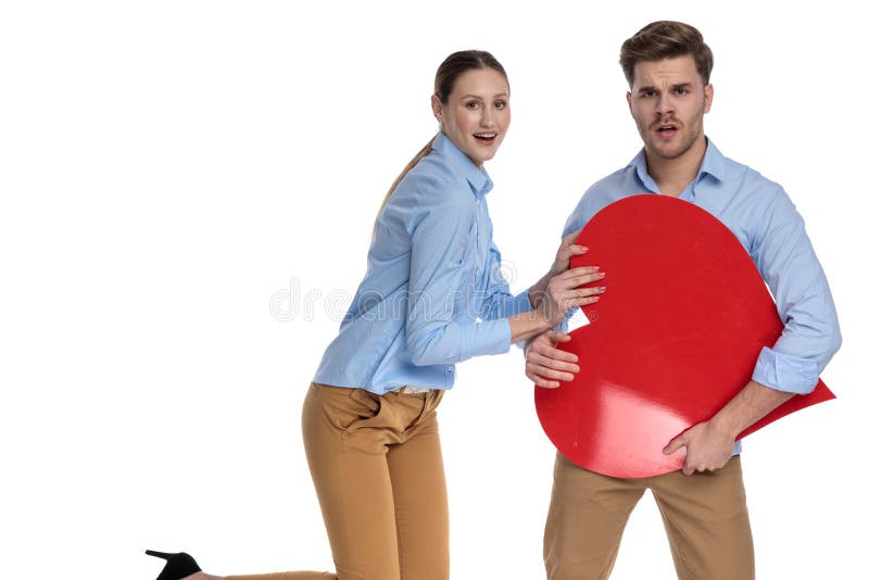 Het jonge gelukkige paar spelen met een groot rood hart stock afbeeldingen Het jonge gelukkige paar spelen met een groot rood hart stock afbeeldingen