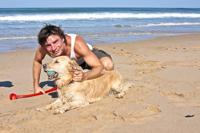 Het jonge kerel spelen met zijn hond royalty-vrije stock afbeelding Het jonge kerel spelen met zijn hond royalty-vrije stock afbeelding