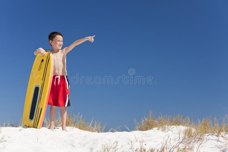 Het jonge Kind van de Jongen op een Strand met het Richten van de Surfplank royalty-vrije stock afbeeldingen Het jonge Kind van de Jongen op een Strand met het Richten van de Surfplank royalty-vrije stock afbeeldingen