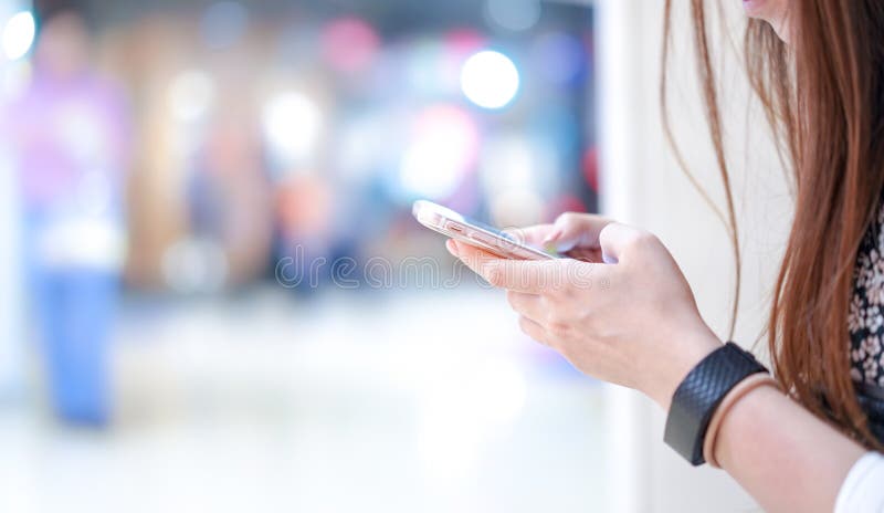 Het jonge meisje houdt smartphone in haar hand (naast hoekmening); spelen, het typen die, het babbelen, met onscherpe bokeh met d stock afbeelding Het jonge meisje houdt smartphone in haar hand (naast hoekmening); spelen, het typen die, het babbelen, met onscherpe bokeh met d stock afbeelding