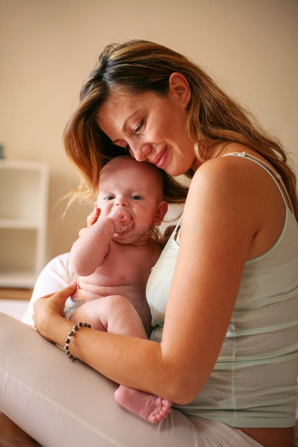 Het jonge moeder spelen met haar babyjongen in bed royalty-vrije stock foto's Het jonge moeder spelen met haar babyjongen in bed royalty-vrije stock foto's