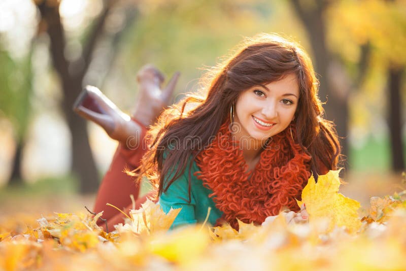 Het jonge mooie vrouw ontspannen in het de herfstpark royalty-vrije stock afbeeldingen Het jonge mooie vrouw ontspannen in het de herfstpark royalty-vrije stock afbeeldingen
