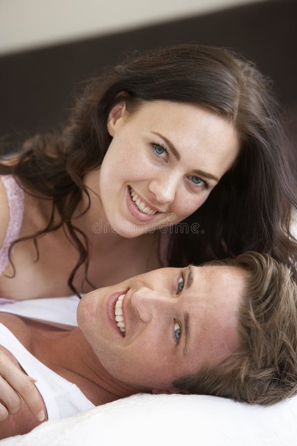 Het jonge Ontspannen van het Paar op Bed stock foto's Het jonge Ontspannen van het Paar op Bed stock foto's