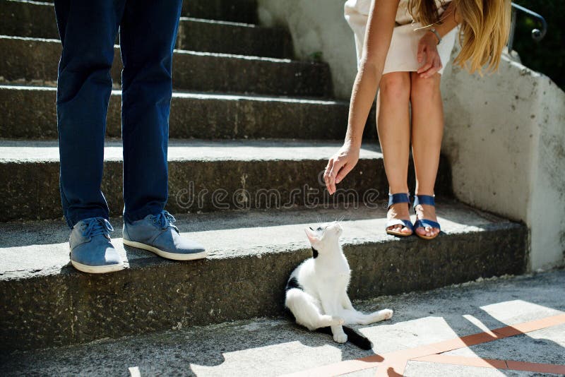 Het jonge romantische paar spelen met een kat in Positano, Italië royalty-vrije stock foto Het jonge romantische paar spelen met een kat in Positano, Italië royalty-vrije stock foto