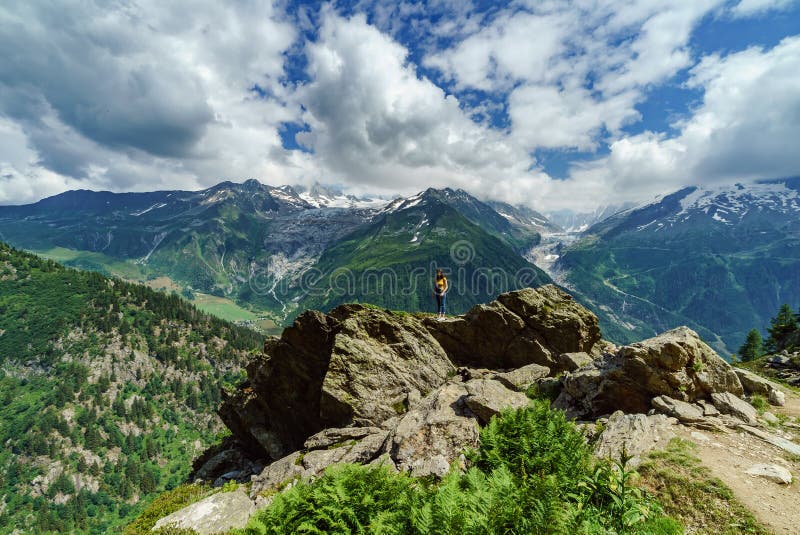 Het jonge tiener stellen op grote steen in Alpen stock afbeelding Het jonge tiener stellen op grote steen in Alpen stock afbeelding