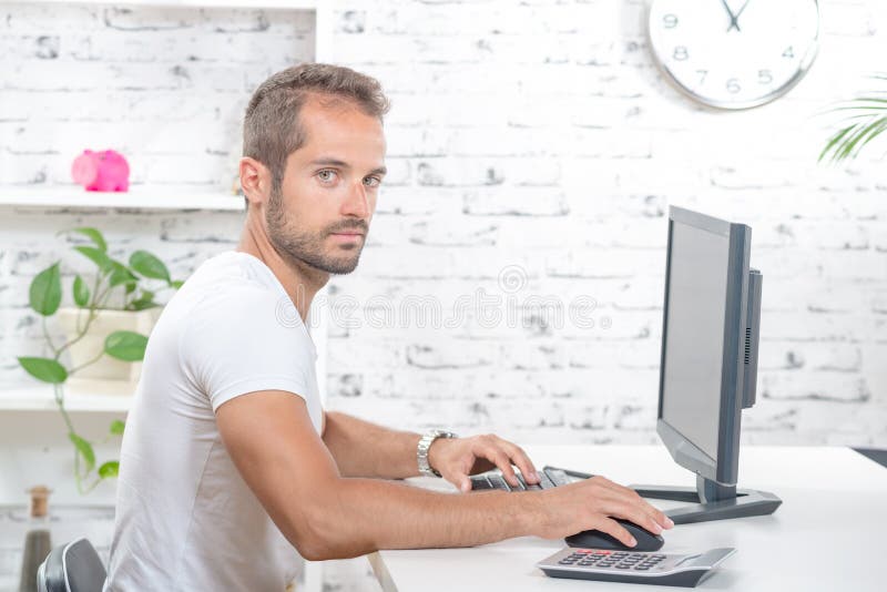 Het jonge uitvoerende werken met zijn computer stock foto Het jonge uitvoerende werken met zijn computer stock foto