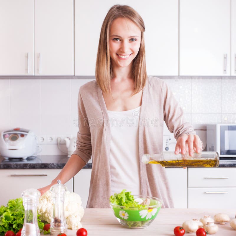 Het jonge vrouw koken in de keuken stock foto Het jonge vrouw koken in de keuken stock foto