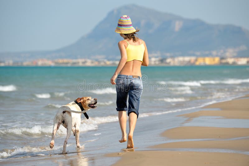 Het jonge vrouw spelen met haar hond op het strand stock afbeeldingen Het jonge vrouw spelen met haar hond op het strand stock afbeeldingen
