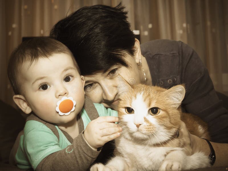Het Kaukasische van de familiemoeder en baby spelen met kat stock foto's Het Kaukasische van de familiemoeder en baby spelen met kat stock foto's
