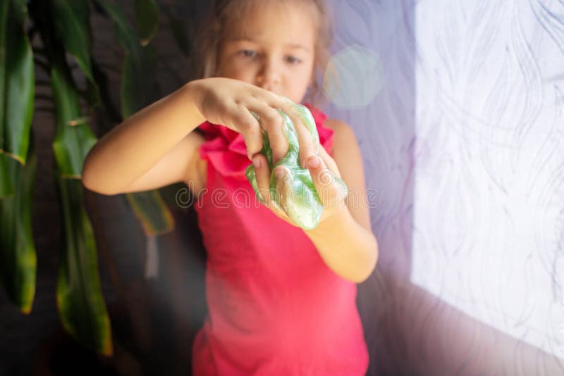 Het kind speelt met toffee een slijm van groene kleur De handen sluiten omhoog stock fotografie Het kind speelt met toffee een slijm van groene kleur De handen sluiten omhoog stock fotografie