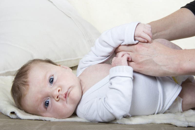 Het kleden van een baby royalty-vrije stock afbeelding Het kleden van een baby royalty-vrije stock afbeelding